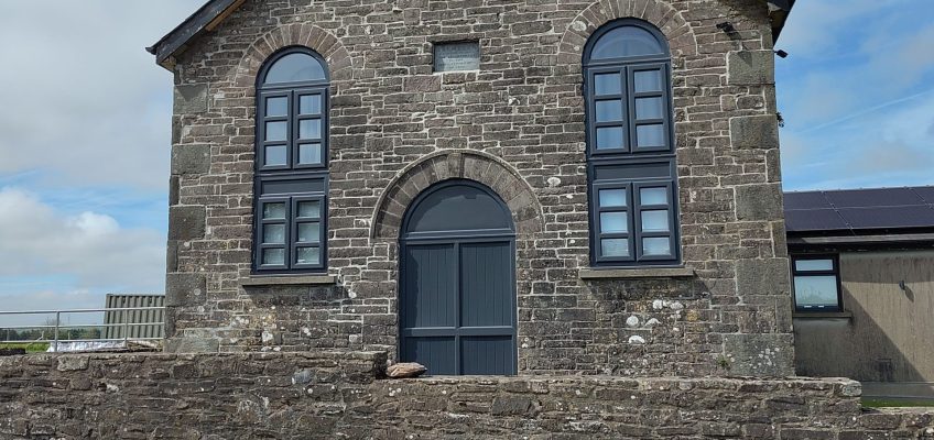 Small chapel with two round-headed windows, converted to residential